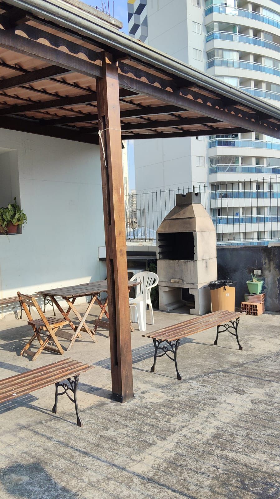 Área externa com churrasqueira e mesas